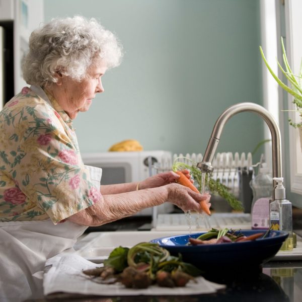 Senior washing veggies